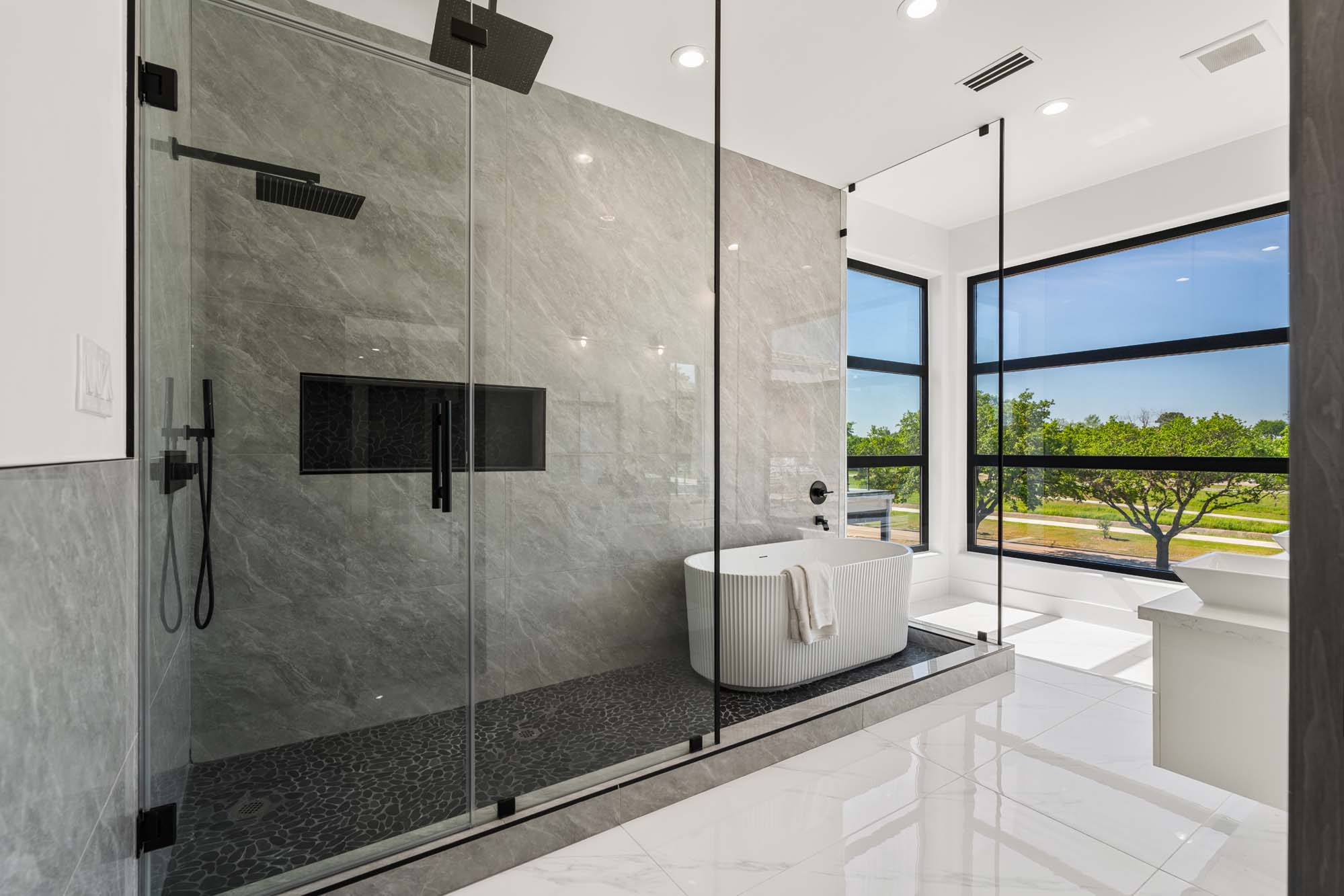Spa-inspired primary bath with frameless rain shower